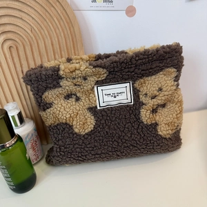 Large capacity teddy bear makeup bag with 'Time to Party' label in cozy home setting