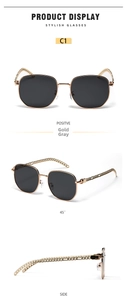 Macro view of square gold metal sunglasses with chain textured temples and dark grey lenses