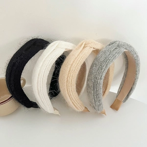 Detailed view of four soft plush knitted headbands in black, cream, apricot and grey