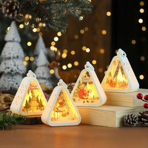 Close-up of four white LED Christmas lanterns with Santa and reindeer prints on wooden steps