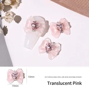 Detail of pink resin bow nail art charm with heart crystal, size 13mm by 14mm