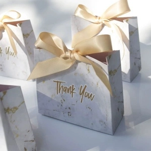 Close-up of marble pattern candy gift bag with golden ribbon bow and Thank You text