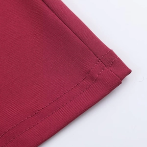 Macro shot of double-needle stitching on burgundy knitted fabric hem for women's dress