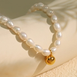 Freshwater pearl necklace with golden spherical pendant and irregular white beads