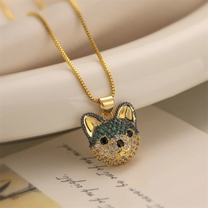 Macro d'un pendentif chiot doré serti de zircons cubiques verts et blancs étincelants