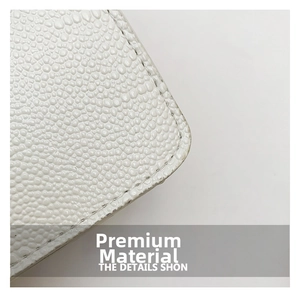 Detailed close-up of white pebbled leather texture with neat stitching on shoulder bag