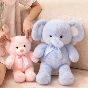 Pink plush teddy bear and blue elephant dolls with checkered bows on a cozy sofa