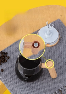 Detail of transparent 400ml self-stirring glass mug with wood texture handle and scale