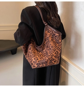 Detail view of large leopard print tote bag worn on shoulder by a model from the back