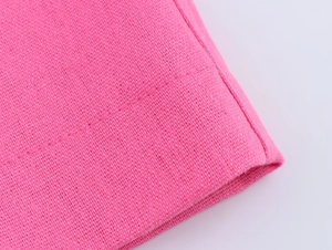 Vue détaillée de la texture du tissu en lin rose fuchsia et des coutures de précision