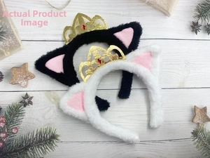 Dettaglio di cerchietti con orecchie di gatto in peluche e corone dorate su sfondo festivo