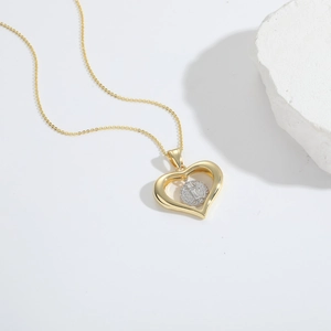 Macro shot of gold heart necklace with zircon inlay and religious portrait pendant