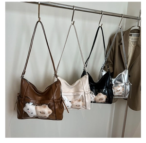 Detailed view of large capacity crossbody ita bags with plush dolls in clear front windows