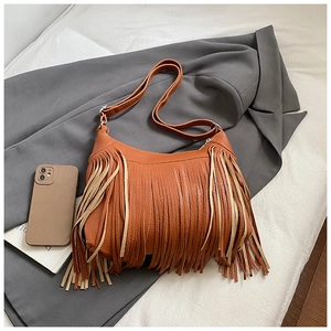 Close-up detail of vintage brown tassel shoulder bag with textured lychee pattern