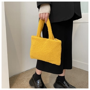 Detail shot of the yellow plush teddy fabric handbag featuring a soft furry texture