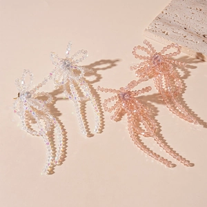 Elegant crystal bow tassel earrings in iridescent white and champagne pink colors