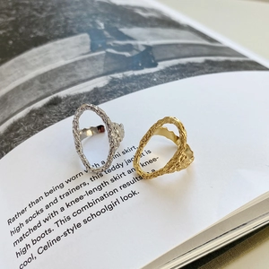 Detailed shot of irregular molten texture rings in gold and silver on an open book