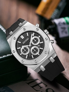 Detail of silver octagonal bezel chronograph watch with black dial and rubber strap