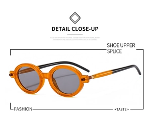 Detailed close-up of oval retro sunglasses with orange acetate frame and grey lenses