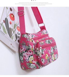 Pink floral crossbody bag with multiple zipper pockets and adjustable canvas strap detail