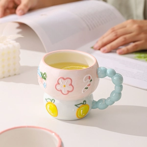 Pink and blue embossed ceramic mug with 3D floral details and unique bubble handle