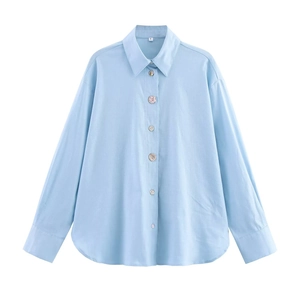 Light blue long-sleeved linen shirt with button details and woven texture in a casual style