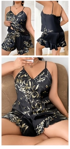 Detail of black floral satin pajama set featuring camisole top and ruffled hem shorts