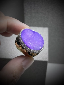 Close-up of a purple druzy quartz crystal ring with sparkling crystal accents in gold