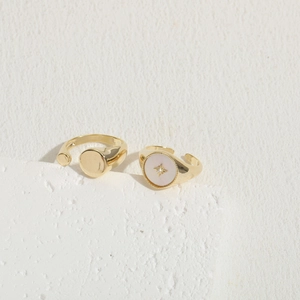 Vintage gold plated shell rings with star zircon details on a stone pedestal