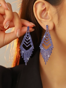 Close-up of model wearing long tassel earrings with sparkling blue rhinestones