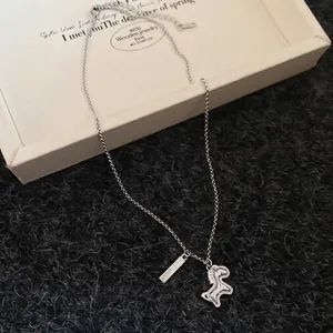 Silver unicorn zircon necklace with Lucky tag on white wooden box and grey velvet