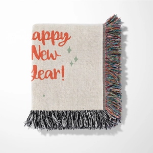 Detail view of Happy New Year woven blanket with colorful tassels and soft knit texture