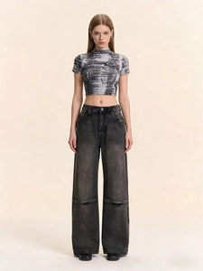 Detailansicht der High-Waist-Jeans mit weitem Bein, Vintage-Waschung und Flügel-Print