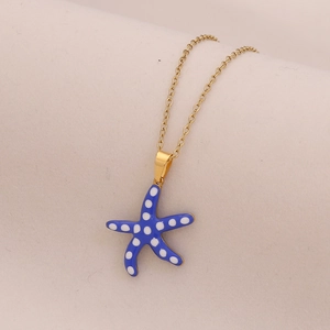 Gold chain necklace featuring a blue starfish pendant with white polka dots pattern