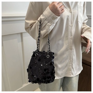 Detail showing high-shine black sequins on a trendy bucket bag with a silver metal chain strap