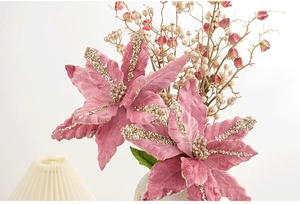 Primo piano di stelle di Natale artificiali rosa con glitter dorati in un vaso decorativo