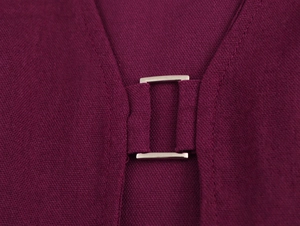 Vue détaillée de la boucle métallique sur le tissu texturé violet foncé d'une robe
