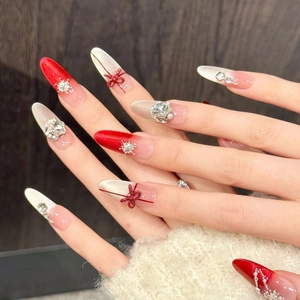 Faux ongles rouges élégants avec nœuds 3D, paillettes flocon et perles forme amande