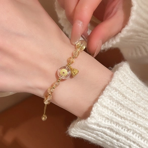 Detail of adjustable beaded bracelet with yellow crystal and golden lotus pod pendant