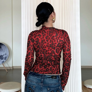 Rear view of women's red leopard print mesh long sleeve top and blue skinny jeans