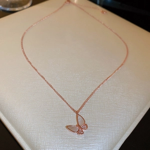 Macro view of rose gold butterfly necklace with mother-of-pearl and cubic zirconia
