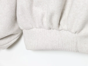 Close-up of soft bomber jacket fabric texture showing hem and cuff junction