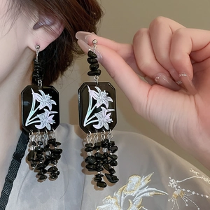 Detail of lily print square tile and black stone fringe tassels on long dangle earrings