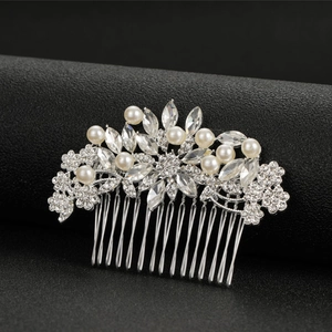 Detailed view of bridal hair comb with shimmering crystals and white pearls on silver metal