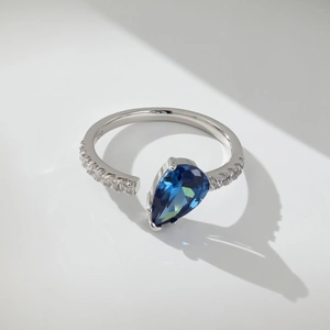 Detail of adjustable S925 silver ring featuring blue pear-cut stone and white zircon accents