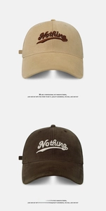 Detail of embroidered 'Nothing' logo on cotton baseball caps in khaki and brown