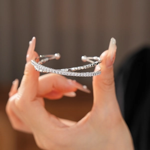 Detail view of silver double-layer crisscross bangle with zircon inlay and beaded texture