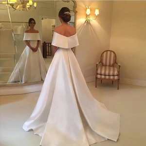 Elegant white off-shoulder satin wedding dress with a sleek train and open back detail