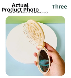 Close-up of portable folding hair brush with built-in mirror in cream white finish