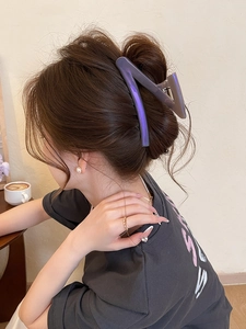 Detail of large purple gradient zigzag claw clip securing a twisted hairstyle on a woman